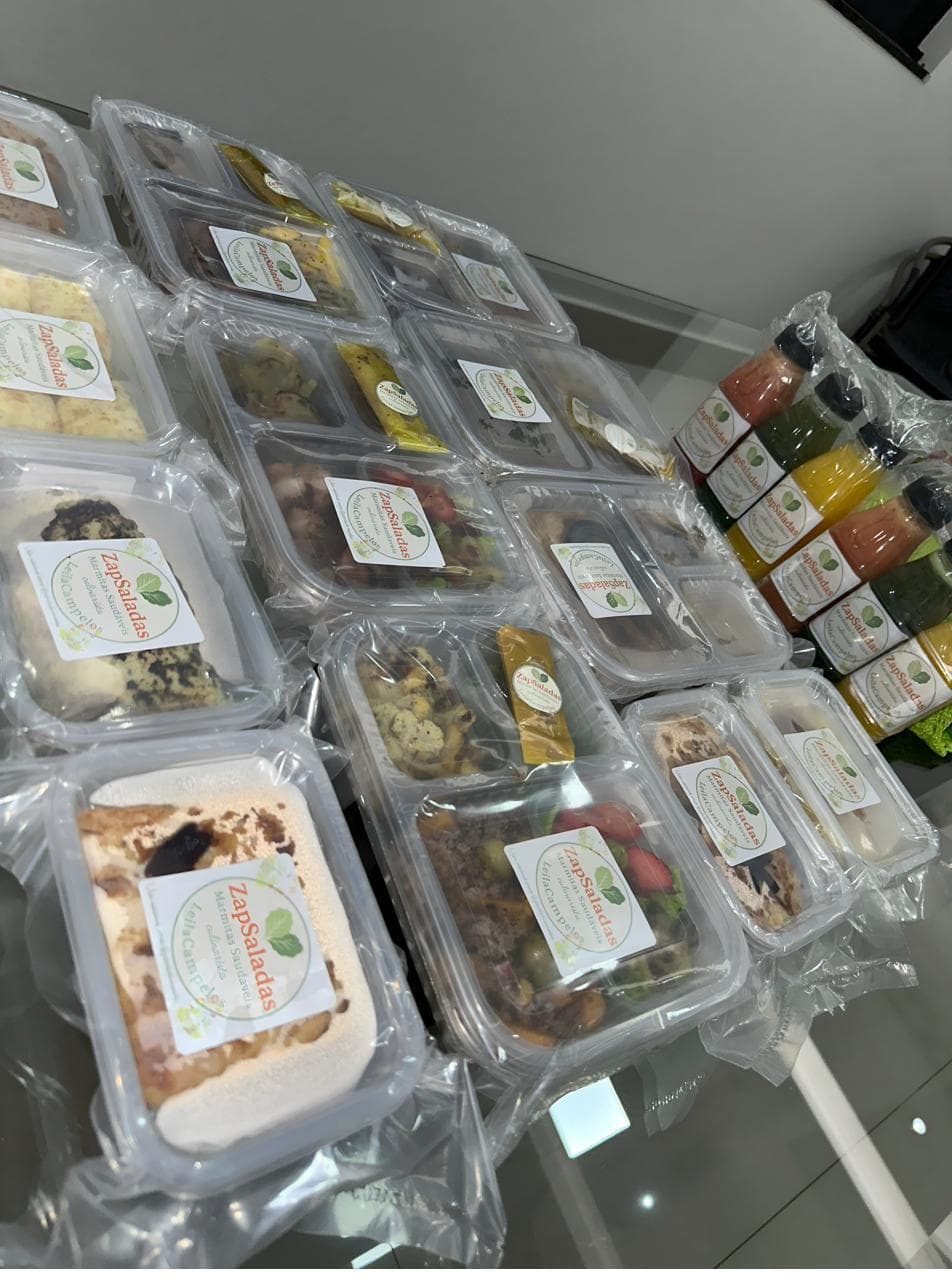 Dezenas de marmitas recém-montadas e etiquetadas, prontas para a entrega do dia